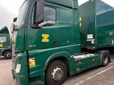 a green truck that is parked in a parking lot