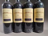 four bottles of wine are lined up in a row on a table