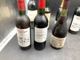 several bottles of wine are lined up on a counter