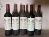six bottles of wine are lined up in a row on a shelf