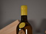 a bottle of wine sitting on a table next to a clock