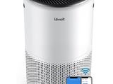 a white and black air purifier next to a cell phone