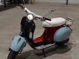un scooter rouge et bleu garé dans un garage