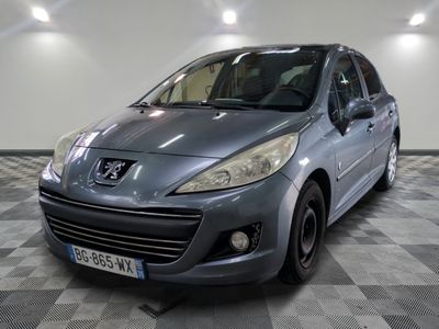 La voiture grise est garée sur le sol en damier du garage.
