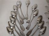 a lot of silver spoons and forks arranged in a circle