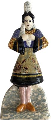 a figurine of a woman in a dress on a rock