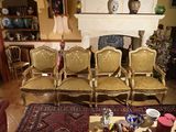 quatre chaises dans un salon avec un tapis au sol