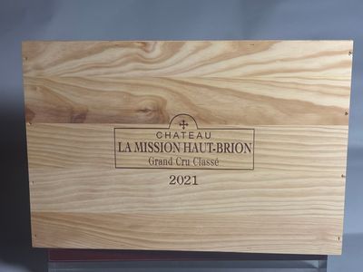 La boîte en bois, posée sur une table, contient une bouteille de vin.