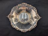 a silver plate with a mirror on it on a black surface