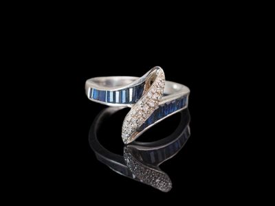 bague en argent ornée de pierres bleues et blanches sur un fond noir