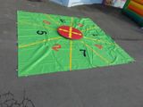une horloge verte et jaune posée par terre, avec des chiffres dessus