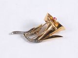 a gold plated brooch with a pink stone in it