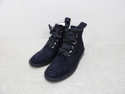 une paire de chaussures noires à lacets posée sur une surface blanche