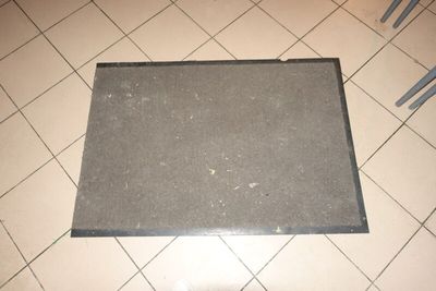 un tapis noir posé sur le sol d'une salle de bains