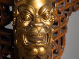 a close up of a wooden table with a gold lion head on it
