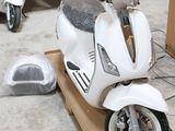 un scooter posé sur une caisse dans un garage