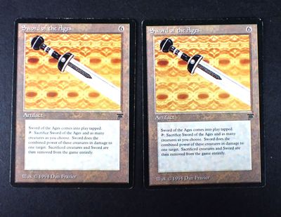 two cards with a sword on them on a table