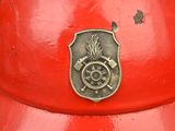 a red fire hydrant with a metal emblem on it