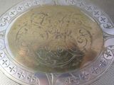 a silver plate with a design on it on a table