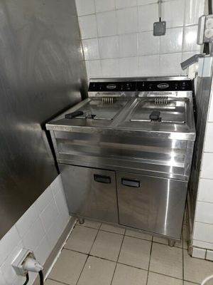 une cuisine équipée d'une cuisinière, d'un évier et d'un réfrigérateur