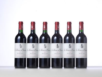 quatre bouteilles de vin rouge sont alignées sur une table