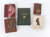 quatre livres empilés les uns sur les autres sur une surface blanche