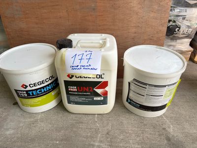 two buckets of oil and a container of cement sit on the ground