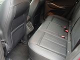 the back seats of a red car with a black seat belt