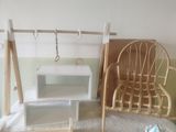 une maison de poupées avec une balançoire et une chaise dans la pièce
