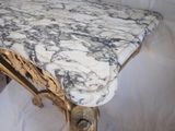 a marble top table with a gold frame on it