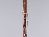 a clarinet on a clear stand with a grey background