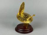 gold plated clock on wooden base on grey background