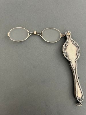 a close up of a pair of glasses and a spoon on a table