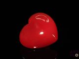 un objet rouge en forme de cœur posé sur une surface noire