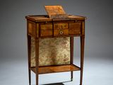 une petite table sur laquelle est posé un ordinateur portable