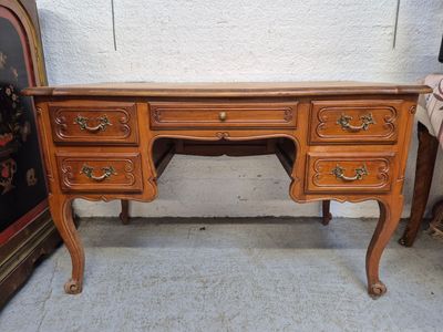 un bureau en bois avec des tiroirs et un miroir dans un coin