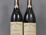 two bottles of red wine sitting next to each other on a table