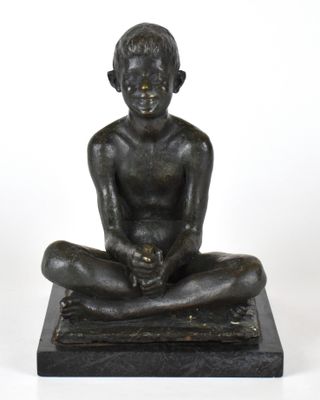 statue en bronze représentant un garçon assis à genoux sur un socle en marbre