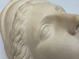 a statue of a man ' s head on a white surface