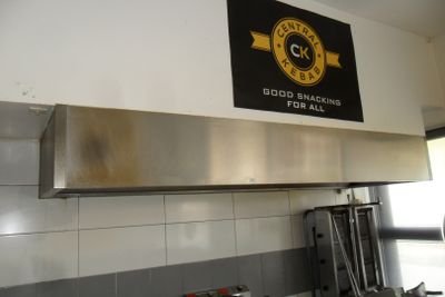 une affiche accrochée au mur au-dessus d'une cuisinière dans une cuisine