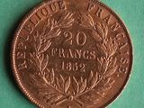 an old french 20 frans coin on a green surface