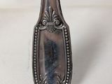 silver plated spoon sitting on a white surface with a white background