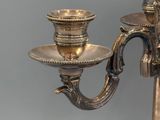 a silver candle holder with two candles on it