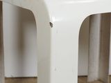 a small white table with a black cat sitting on top of it