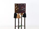 une image représentant un petit tabouret en bois dont les pieds sont ornés de pompons
