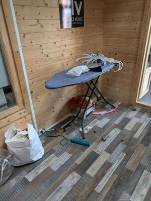 a room that has a table and a ironing board in it