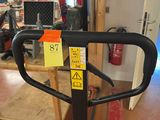 a black and yellow sticker on the handle of a hand truck