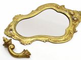 a mirror and a hook on a white surface