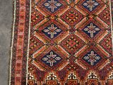 an old rug with a geometric design on a grey floor