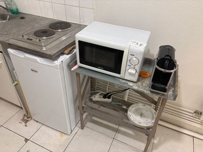 a microwave and a small refrigerator in a small kitchen